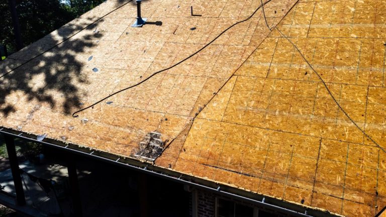 Roof of house in process of being replaced with deck boards.